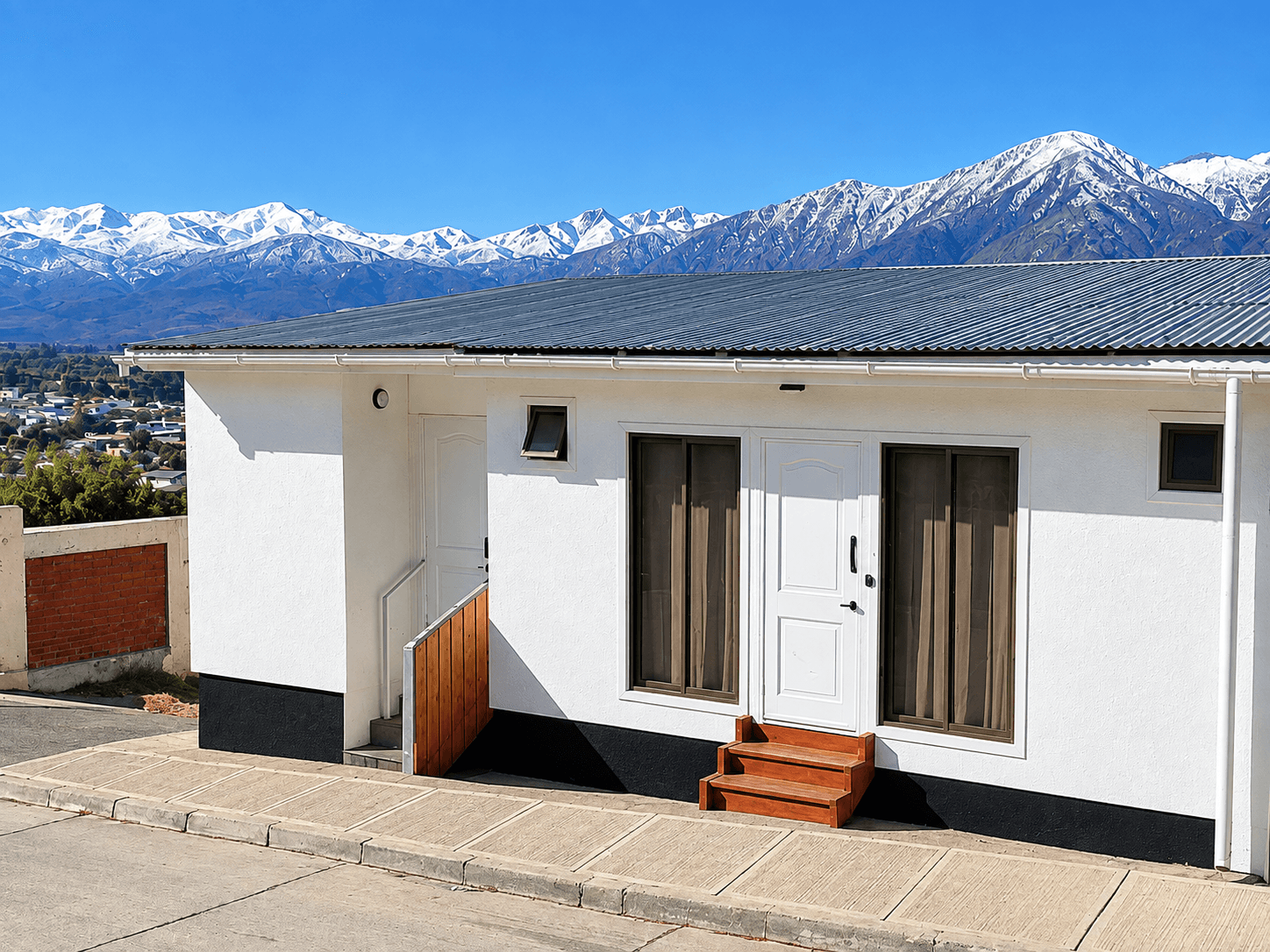 Fachada de Vista Valle con montañas nevadas al fondo